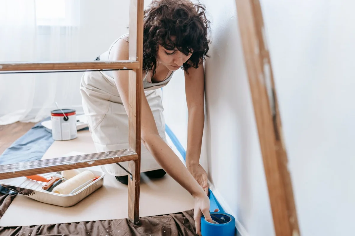 Peintre posant les protections avant un chantier de remise en état
